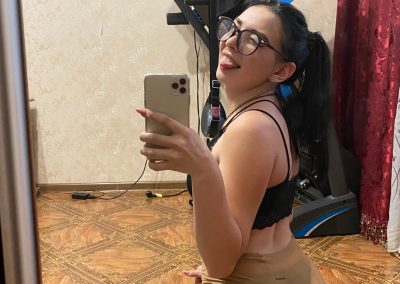 Sexy girl in underwear and pantyhose sticking out tongue taking selfie on her knees