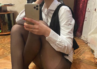 girl wearing dress shirt,glasses and black pantyhose sitting taking selfie