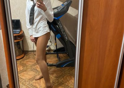 Fit schoolgirl with pigtails taking selfie of her pantyhose legs