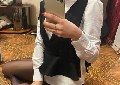Girl in black pantyhose wearing dress shirt and glasses sending selfie
