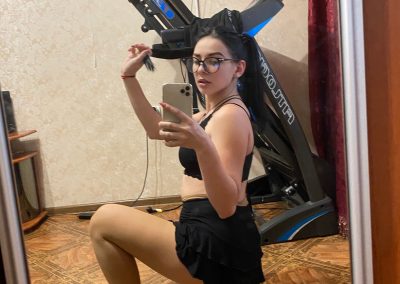Sexy girl with glasses squatting in skirt and pantyhose