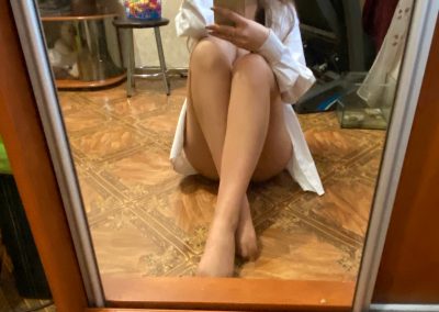 Sexy girlfriend in nude pantyhose sitting on floor selfie