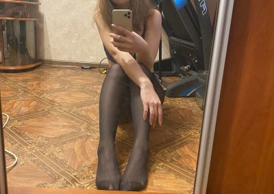 Sexy girl with santa hat in pantyhose taking selfie