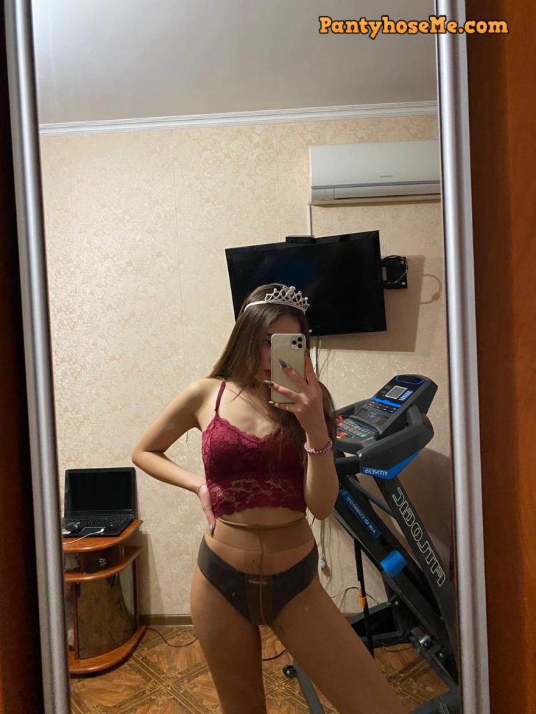 Sexy girl in shirt, panties and pantyhose sending selfie
