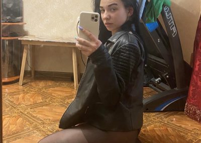 Sexy girl amber in leather coat and black pantyhose taking selfie