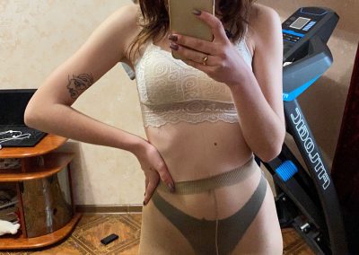 Sexy girl in hat, sports bra, panties and pantyhose selfie