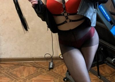 Girl with nice tits in red bra, black coat and black pantyhose taking selfie in mirror