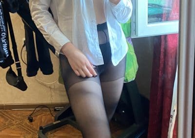 Pretty brunette wearing glasses and pantyhose taking selfie in unbuttoned shirt