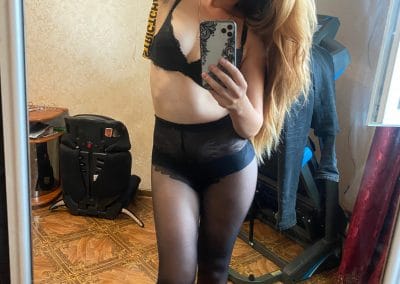 Pretty girl with hair to her side taking selfie in pantyhose